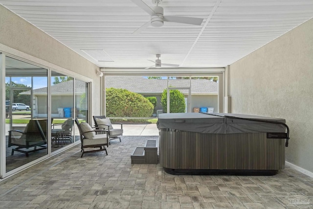 unfurnished sunroom with a hot tub and ceiling fan