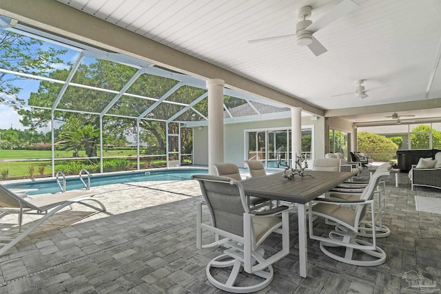 view of patio with ceiling fan and glass enclosure