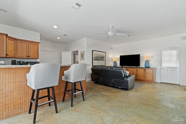 kitchen with ceiling fan, kitchen peninsula, and a kitchen bar