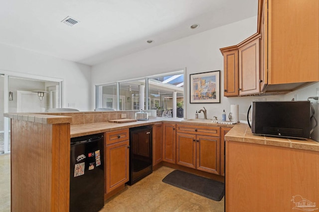 kitchen with kitchen peninsula, wine cooler, sink, and black refrigerator