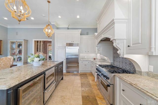 3410 N 18th Ave, Pensacola, FL 32503 - kitchen featuring white cabinets, built in appliances, a notable chandelier, a sink, and beverage cooler