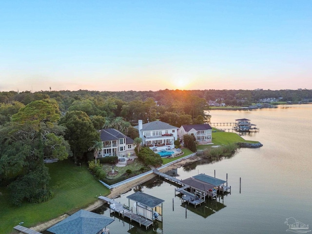 aerial view at dusk featuring a water view