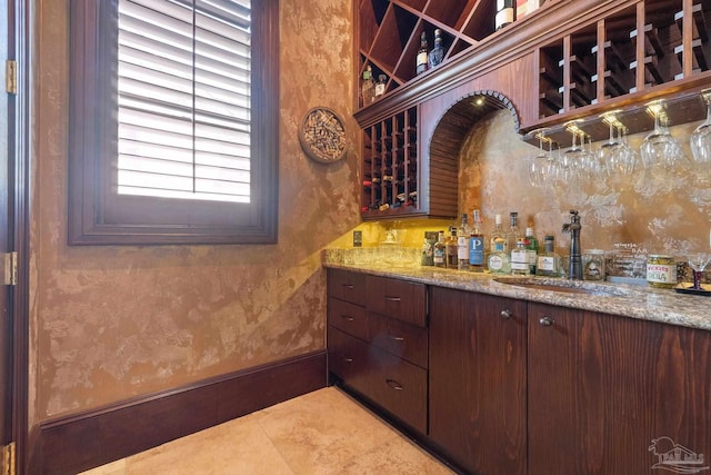 3410 N 18th Ave, Pensacola, FL 32503 - wine room featuring a dry bar, light tile patterned flooring, a sink, and baseboards