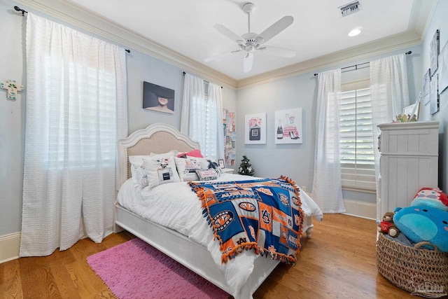 bedroom featuring crown molding, multiple windows, hardwood / wood-style flooring, and ceiling fan