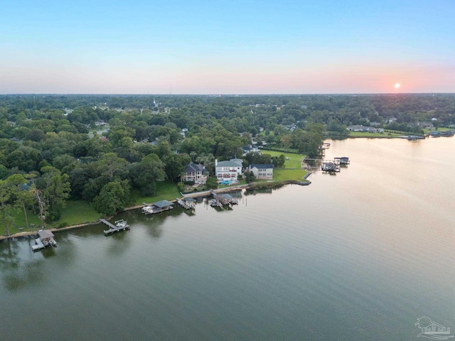 aerial view at dusk featuring a water view