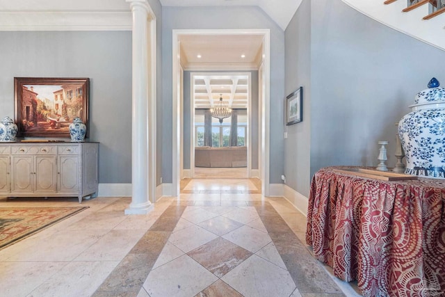 foyer entrance featuring an inviting chandelier, ornamental molding, and decorative columns