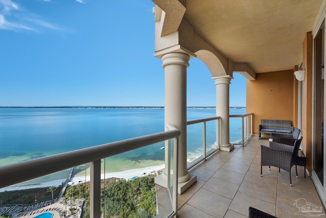 balcony featuring a water view and a beach view