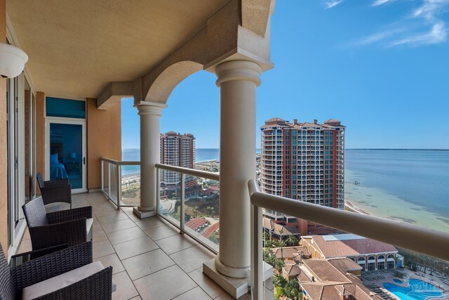 balcony featuring a water view and a beach view