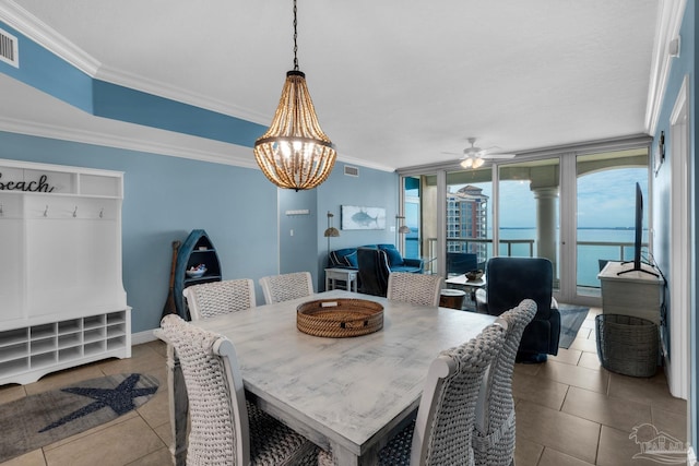 dining area with a water view, ornamental molding, and light tile patterned flooring