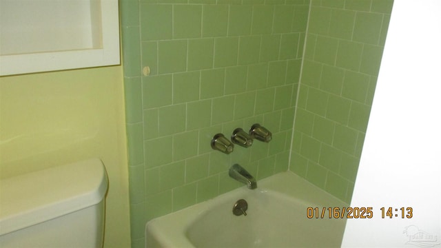 bathroom featuring toilet and tiled shower / bath