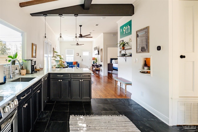 kitchen with ceiling fan, sink, stainless steel appliances, hanging light fixtures, and kitchen peninsula