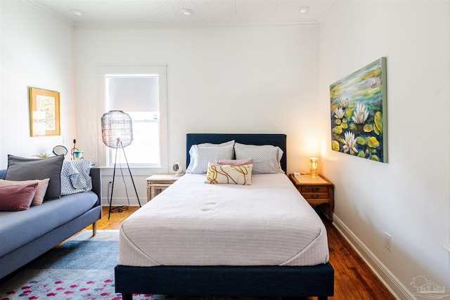 bedroom with dark hardwood / wood-style flooring and ornamental molding