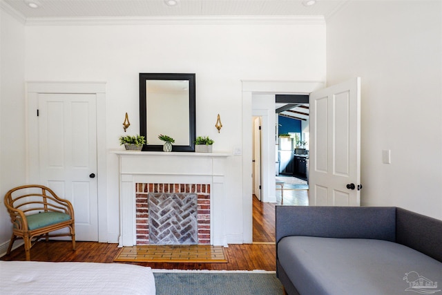 bedroom featuring a fireplace, a closet, wood-type flooring, and ornamental molding