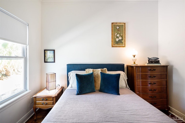 bedroom with a baseboard heating unit and dark wood-type flooring