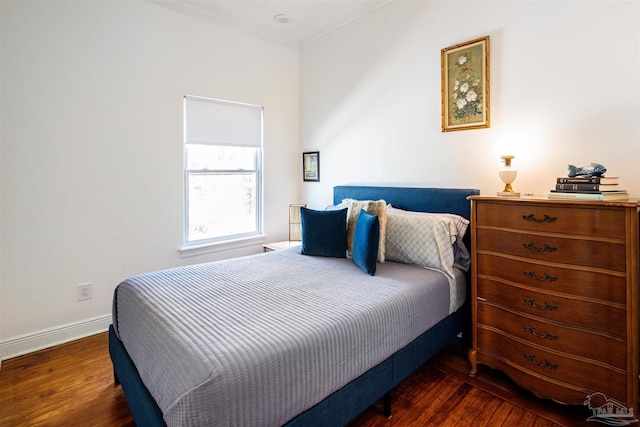 bedroom with crown molding and dark hardwood / wood-style floors