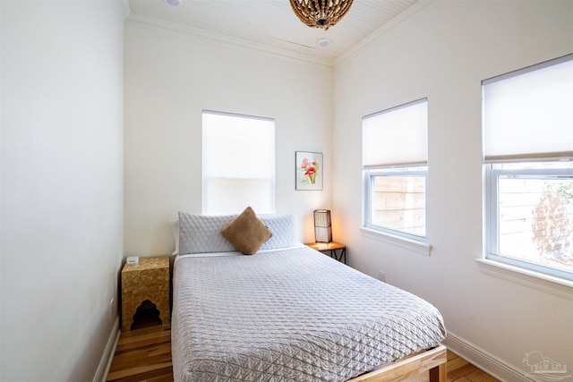 bedroom with hardwood / wood-style floors and crown molding