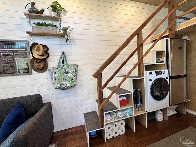 laundry area with washer / dryer, dark hardwood / wood-style floors, and wood walls