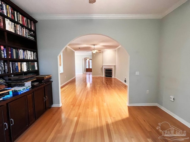 interior space featuring ceiling fan, light hardwood / wood-style floors, and ornamental molding