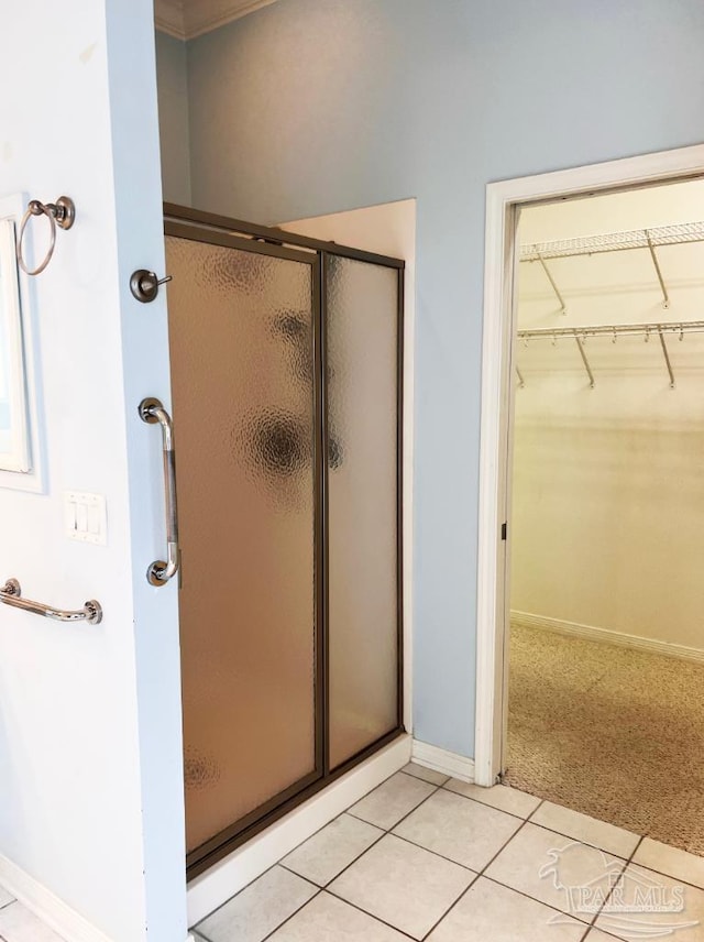 bathroom with tile patterned flooring and a shower with shower door