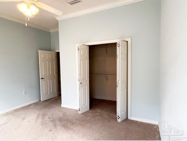 unfurnished bedroom with crown molding, carpet, ceiling fan, and a closet