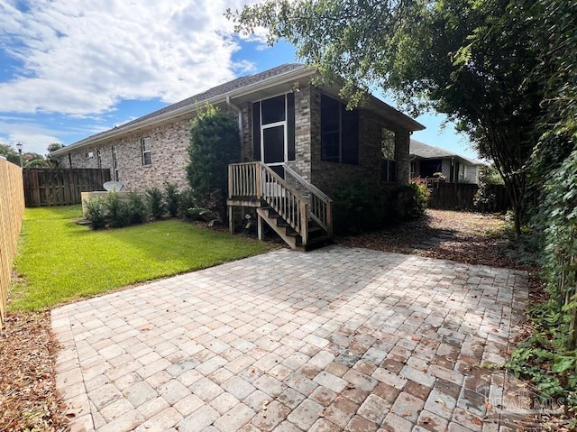 view of side of home featuring a yard and a patio