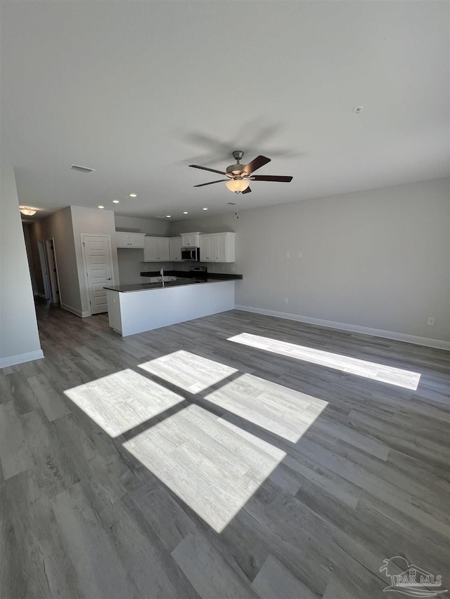 unfurnished living room featuring sink, light hardwood / wood-style flooring, and ceiling fan