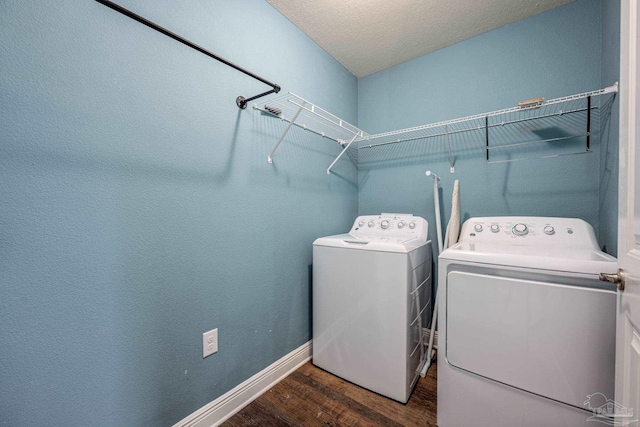 washroom with independent washer and dryer, dark hardwood / wood-style flooring, and a textured ceiling