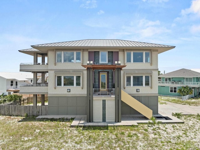 back of property with metal roof, stairway, and a standing seam roof