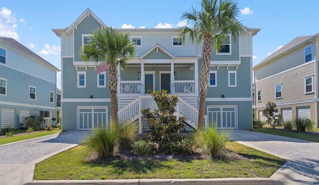 6635 Carlinga Dr, Pensacola, FL 32507 - coastal home with gravel driveway, a porch, stairway, and an attached garage