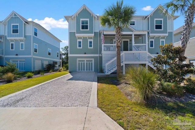 6635 Carlinga Dr, Pensacola, FL 32507 - coastal home with driveway, stairway, covered porch, board and batten siding, and a garage