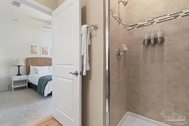 bathroom with wood-type flooring and tiled shower