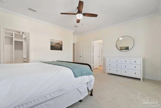 bedroom featuring a closet, light colored carpet, a walk in closet, ornamental molding, and ceiling fan