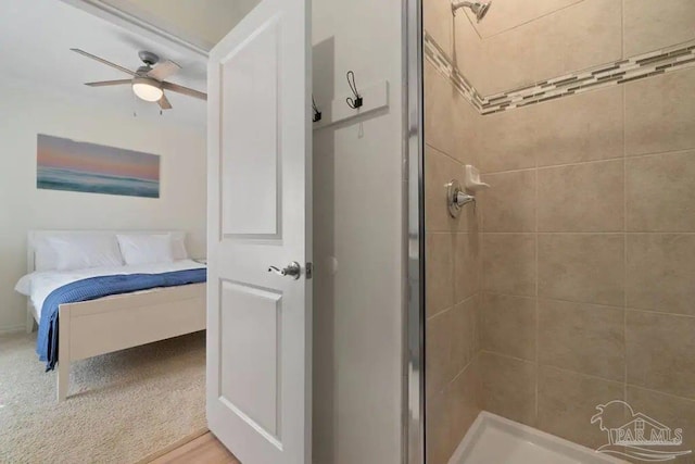 bathroom featuring ceiling fan and a shower with shower door