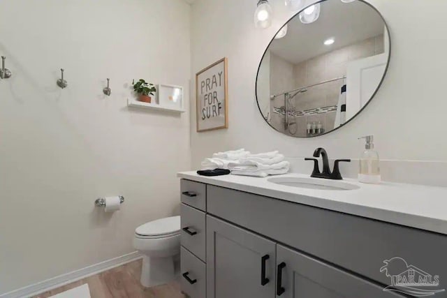 bathroom with vanity, hardwood / wood-style floors, toilet, and curtained shower