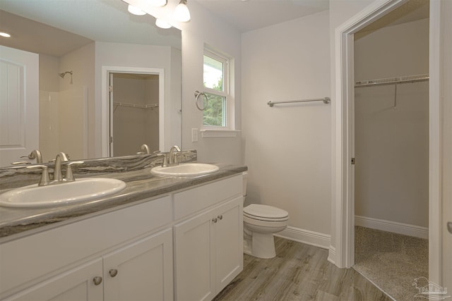 bathroom with vanity, hardwood / wood-style floors, walk in shower, and toilet