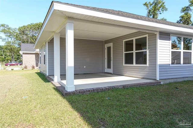 rear view of property featuring a patio and a lawn