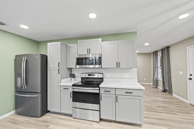 3985 Whitehall Dr, Pace, FL 32571 - kitchen with light countertops, tasteful backsplash, light wood-style floors, and stainless steel appliances
