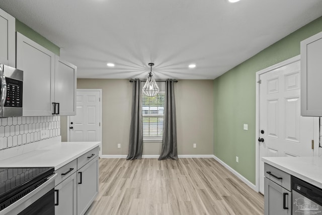 3985 Whitehall Dr, Pace, FL 32571 - kitchen with light countertops, stainless steel appliances, baseboards, pendant lighting, and light wood-style flooring