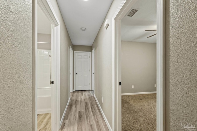 3985 Whitehall Dr, Pace, FL 32571 - hall featuring wood finished floors, a textured wall, baseboards, and visible vents