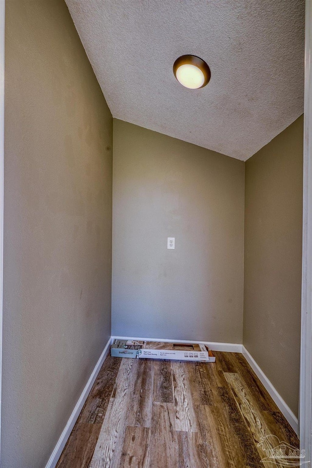3985 Whitehall Dr, Pace, FL 32571 - unfurnished room with baseboards, a textured ceiling, and wood finished floors