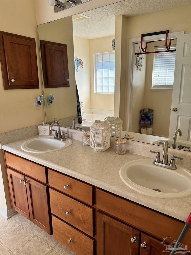 bathroom featuring vanity, a wealth of natural light, and a textured ceiling