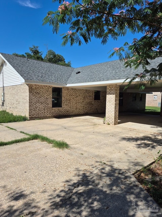 5757 Melrose Dr, Milton, FL 32570 - view of side of property with brick siding, driveway, a shingled roof, and an attached carport