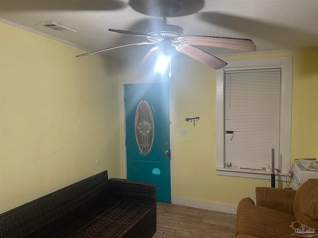 interior space with ceiling fan, a textured ceiling, and light wood-type flooring