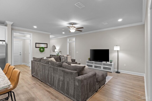 living area featuring light wood-style flooring, recessed lighting, ceiling fan, baseboards, and crown molding
