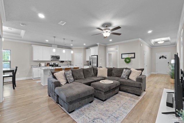 living area featuring baseboards, recessed lighting, light wood finished floors, crown molding, and a ceiling fan