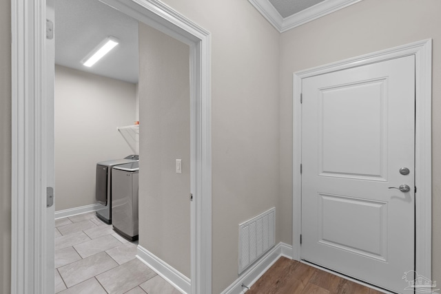 laundry area featuring crown molding, independent washer and dryer, and baseboards