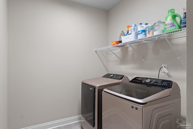 laundry area featuring washer and dryer, baseboards, and tile patterned floors
