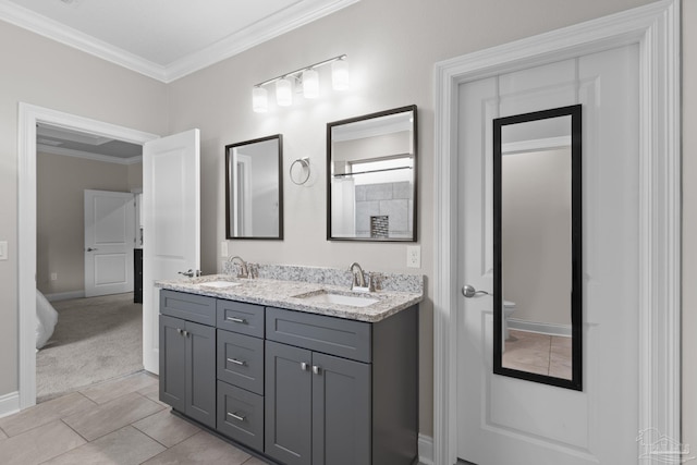 bathroom with toilet, crown molding, double vanity, baseboards, and tile patterned floors