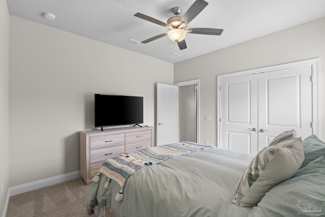 bedroom featuring light carpet, a closet, baseboards, and a ceiling fan