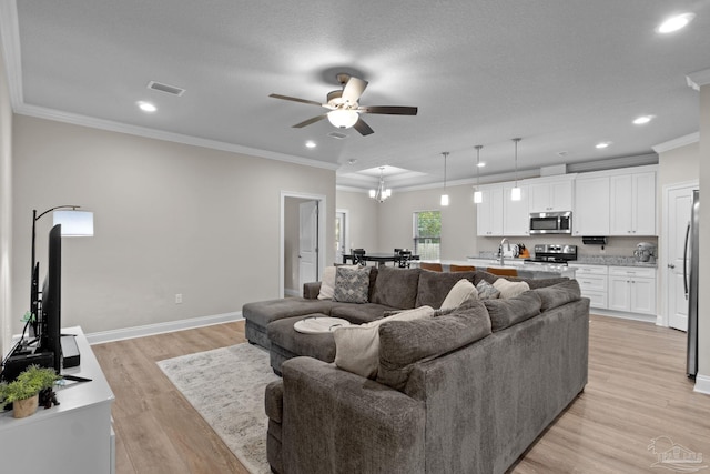 living room with a ceiling fan, crown molding, light wood-style flooring, baseboards, and recessed lighting